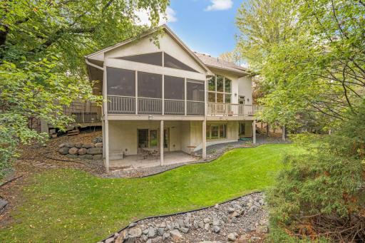 Large Vaulted screened Porch with Trex flooring above private stamped concrete Patio walkout.