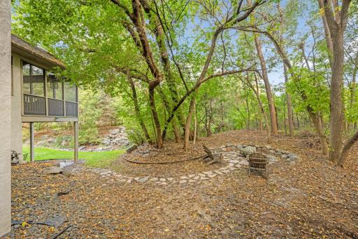 Back overlooks landscaped berm with Pine, Birch and berry trees, trap boulders, and water feature. Stoned path leads to firepit area. Many perennials cover the berm from spring through fall, while snow cover on the pines provides added privacy.