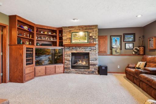 Retreat to this fabulous amusement room that offers stone fireplace and wonderful custom built-ins.