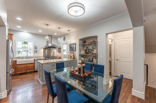 A chef's dream! This modern kitchen and dining area featuring professional stainless steel appliances, granite countertops, hardwood floors, and a central island.