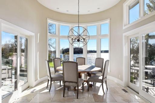 Dine in natural light in the dining space, embraced by a panorama of windows that invite the outdoors in. Access to the gorgeous new deck overlooking the pool and lake. Ideal for transitioning after dining.