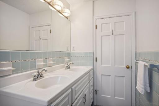 Main floor bathroom with resurfaced bath tub & updated vanity featuring double sinks.