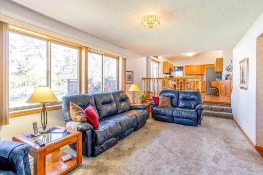 Bright and open family room with a cozy gas fireplace and oversized windows with backyard views.