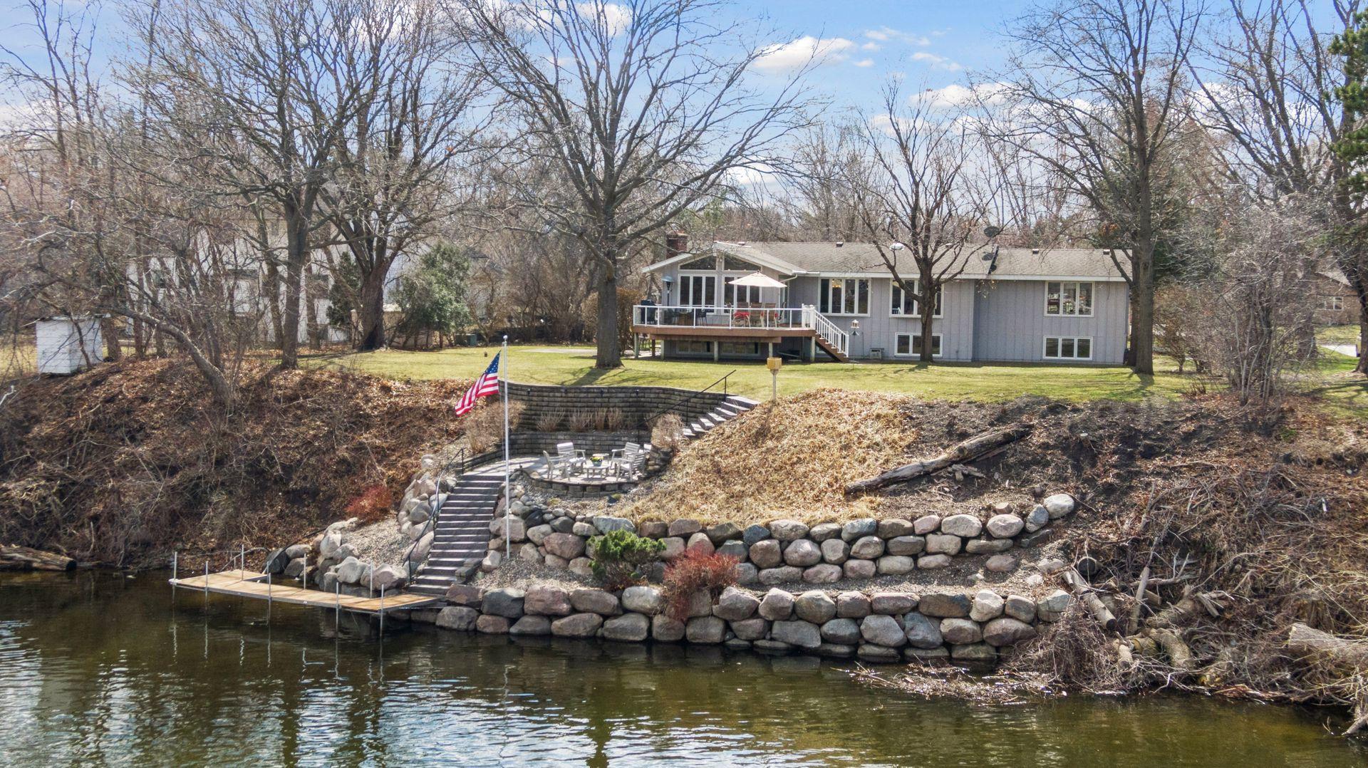 Extensive landscaping, 24' wide dock, boulder walls, and patio dining/entertaining patio