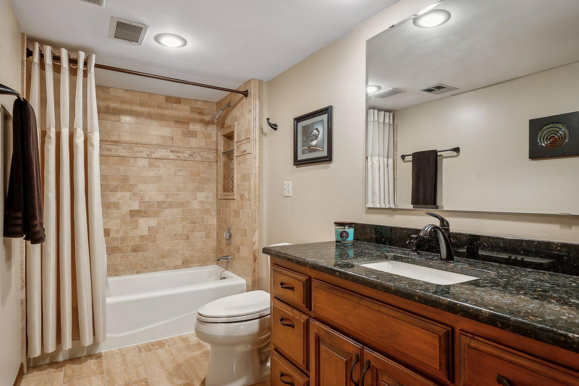 Lower level bath is updated just as the others in the home. Beautiful granite vanity with soft close and tiled shower surround.