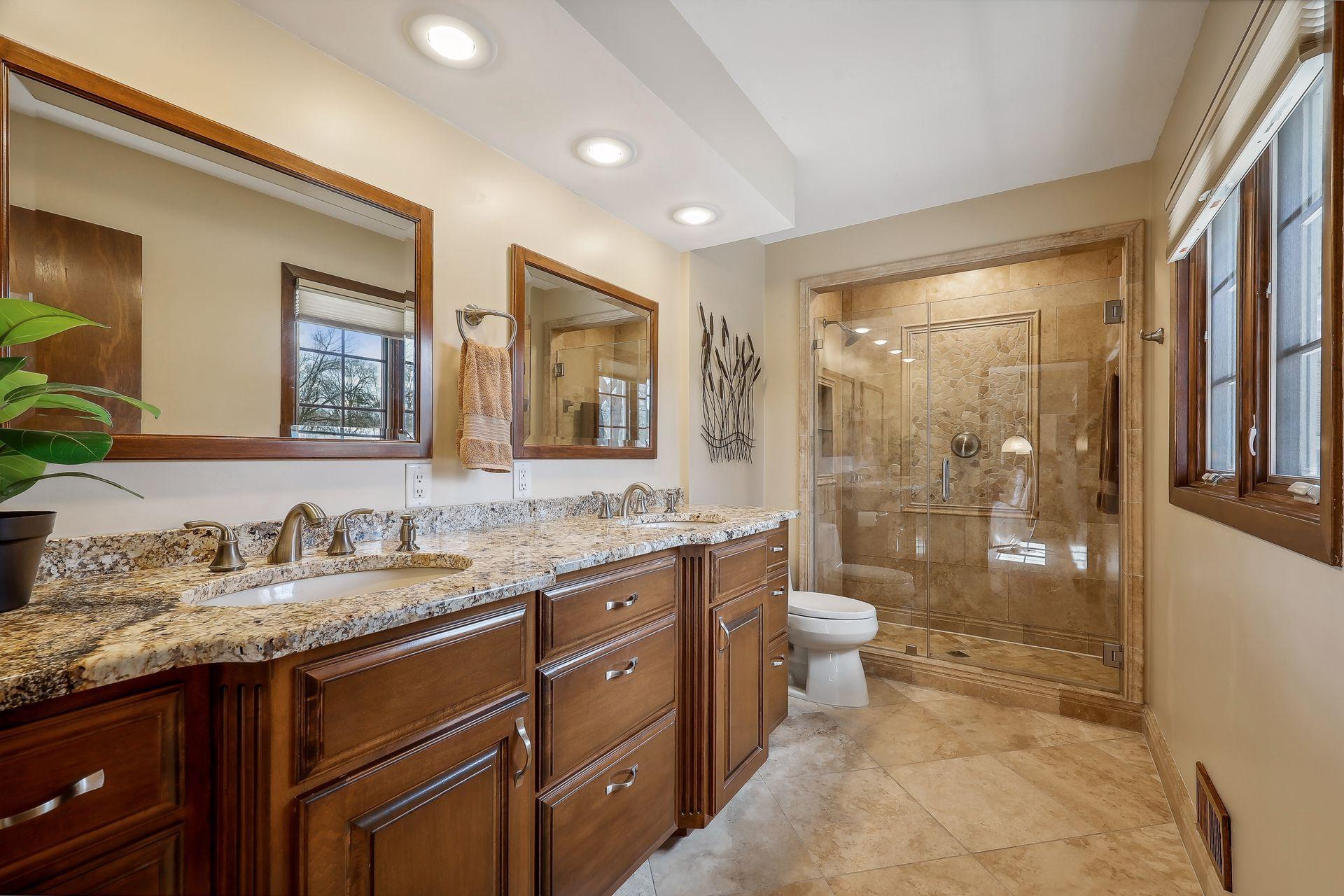 Primary bath includes a walk in shower, dual vanity with granite countertops, ceramic tile and custom cabinets with soft close