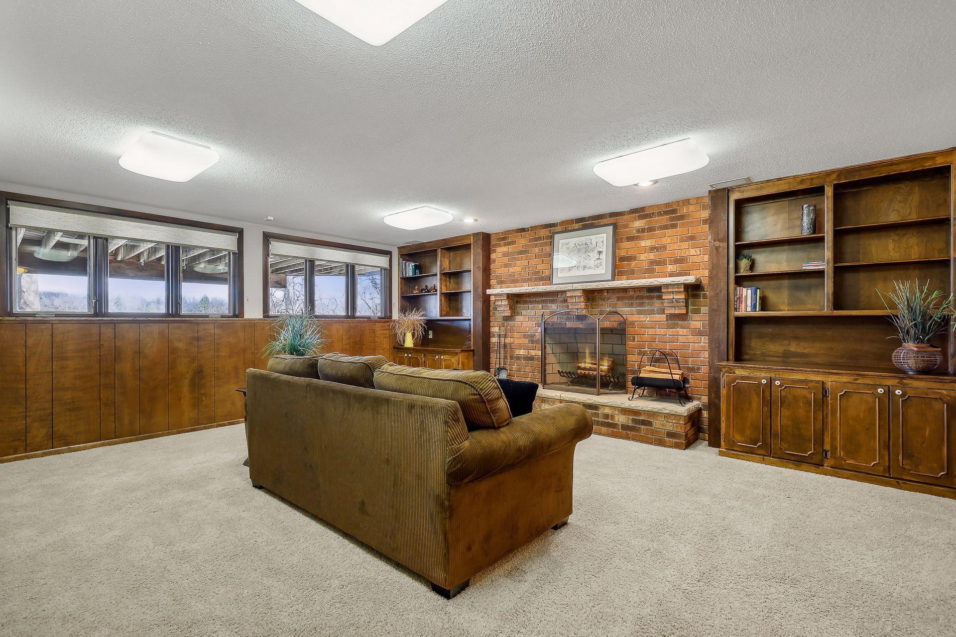 Lower level amusement room offers a woodburning fireplace with brick surround and bright daylight windows