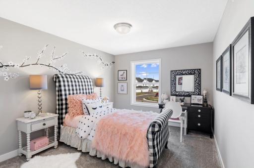 (Photo of a decorated model, actual homes finishes will vary) One of two generously sized upper level secondary bedrooms with spacious closets.