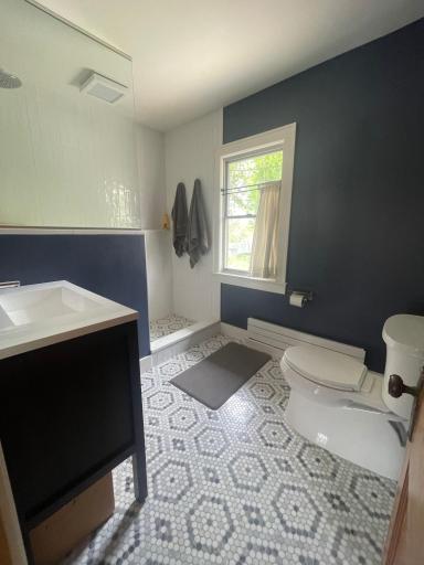 Main bath with marble tile floors, mahogany vanity, modern shower with new fixtures.