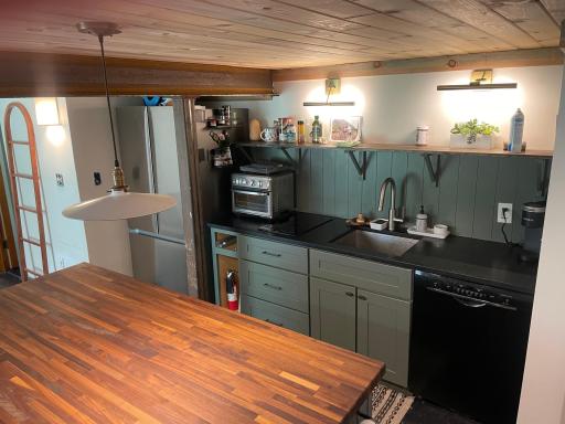 Kitchenette includes induction 2 -top stove, full kitchen sink, ample storage and full size fridge with new dishwasher.