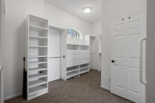 Spacious walk-in closet with organization systems.