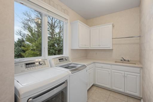 Well equipped laundry room on the main level with a sink & plenty of storage.