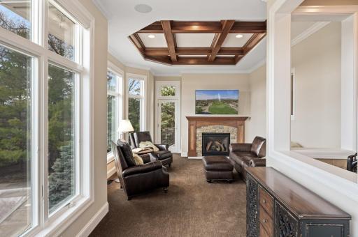 Newly added sunroom with coffered ceilings and a gas fireplace, creating additional spaces for relaxation and socializing.