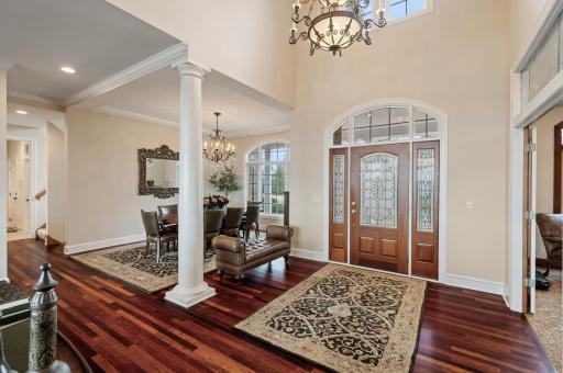 The 2-story ceilings and natural wood accents create a warm and inviting atmosphere, complemented by cherrywood elements and refined white woodwork throughout.