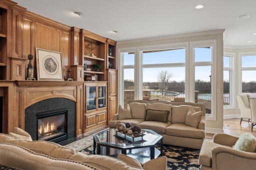 The living room, with its gas fireplace framed by a stone surround, is a cozy retreat.
