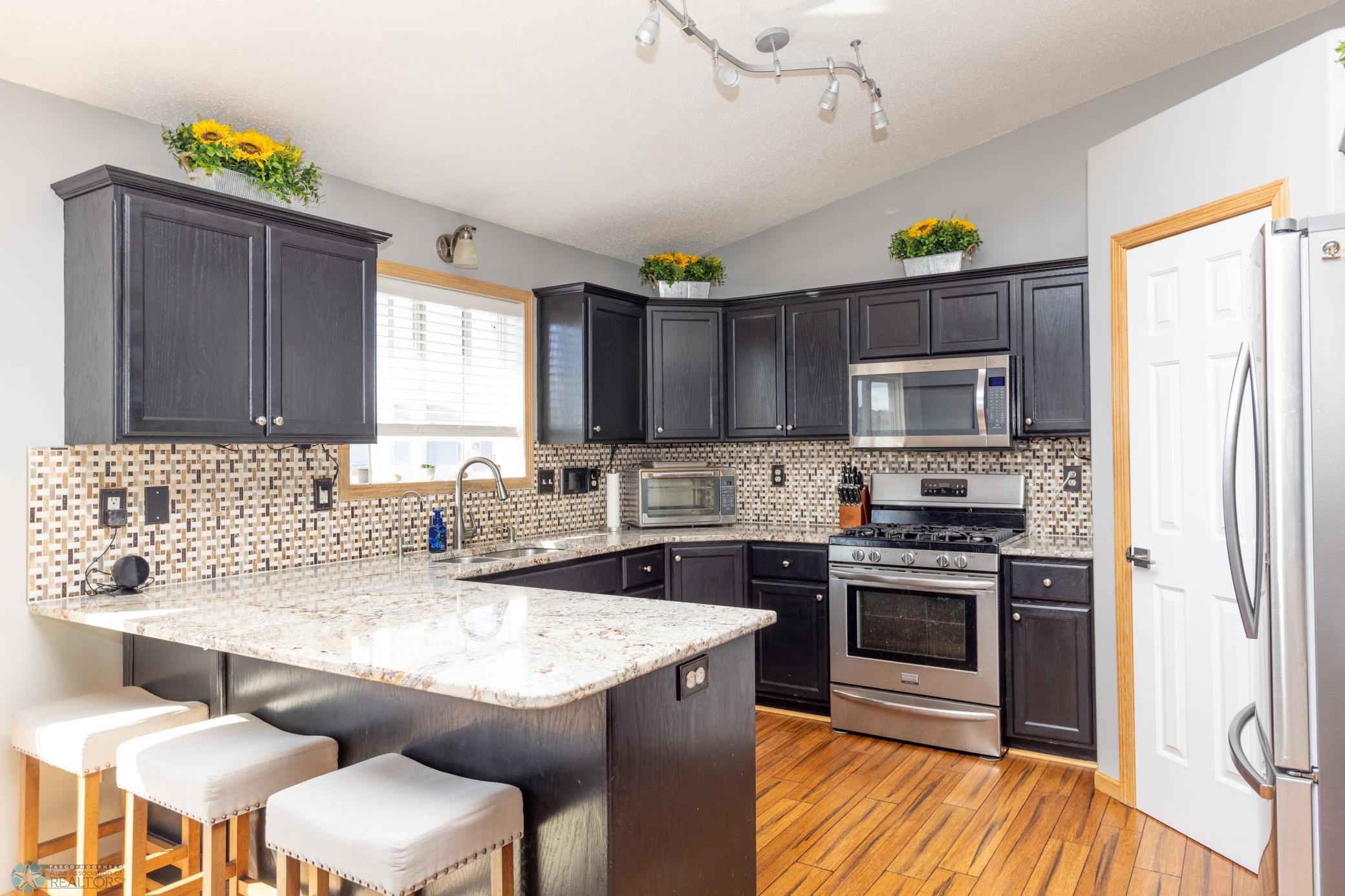 Kitchen has a new stainless steel refrigerator in 2022, a gas range, granite countertops, and a large walk in pantry.
