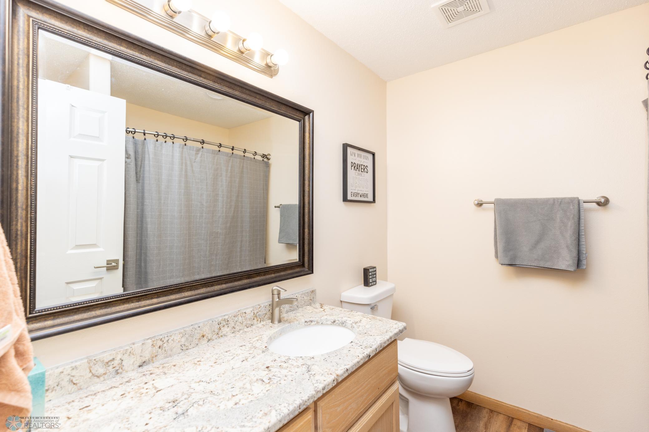 Full bathroom with granite countertop.