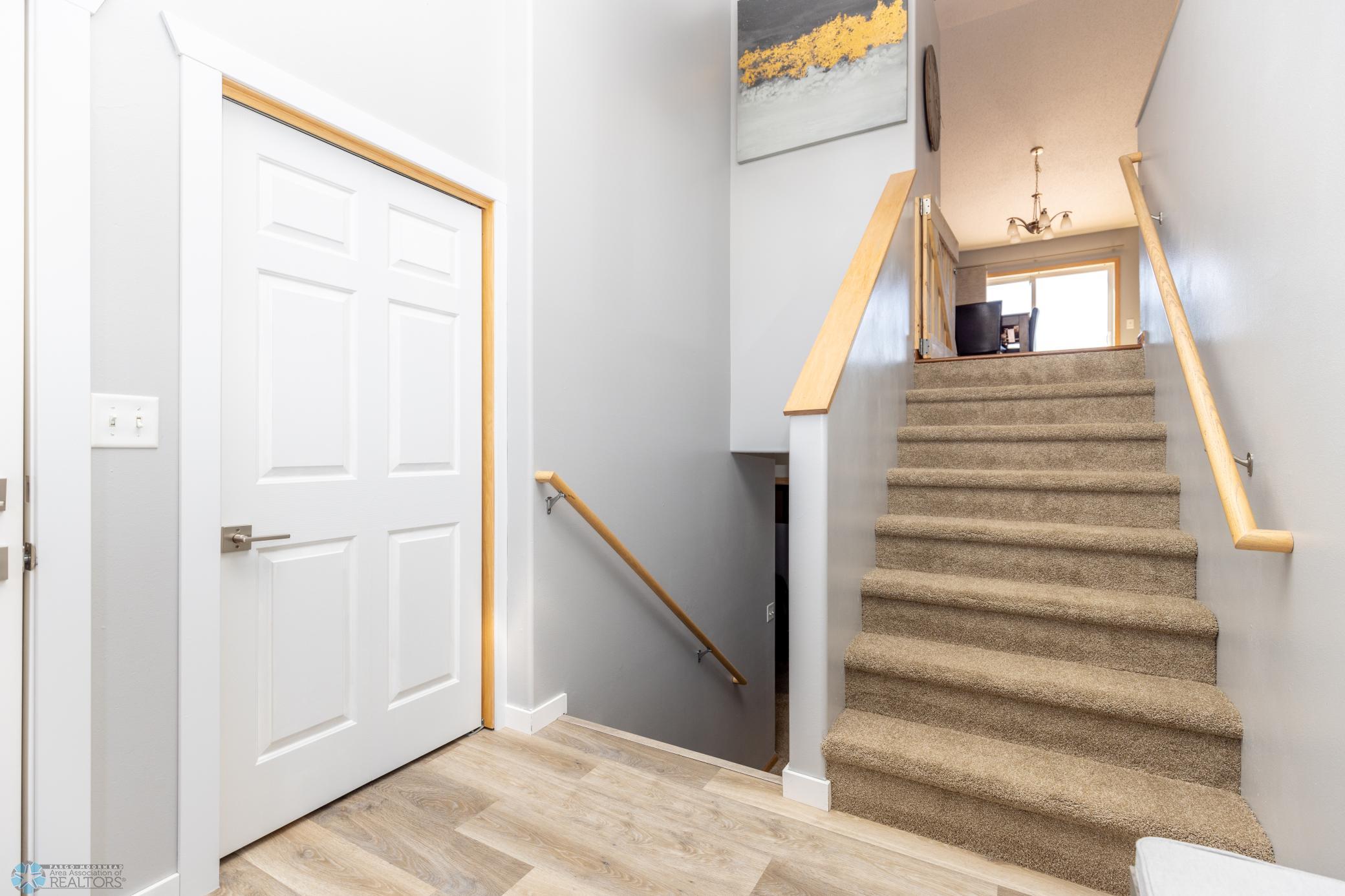 New vinyl planking in entryway and new carpet on stairs going up and down.