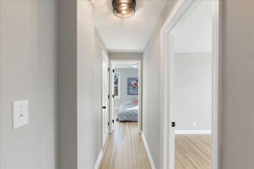 Discover the charm of beautifully refinished wood flooring adorning the upper-level bedrooms, while modern light fixtures inject a touch of contemporary elegance.
