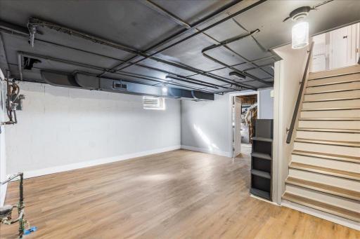 Unwind in this partially finished basement, featuring new flooring and a modern black industrial ceiling that sets the stage for entertaining or simply kicking back and relaxing.