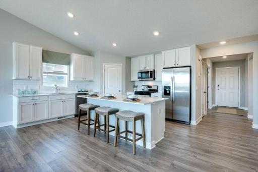 Beautiful designer kitchen, with lots of space and natural light. Photo of model home, colors will vary.