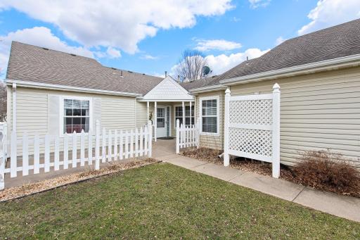 Experience outdoor living at its finest with an attached 2-car garage offering ample parking and storage, and a front patio overlooking a flat green lawn, perfect for enjoying the fresh air and serene surroundings.