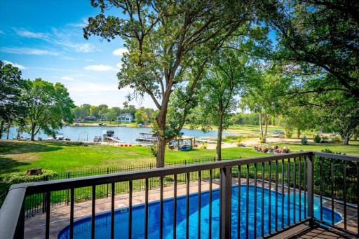Serene view off deck of pool area, back yard and lake. No stairs to the lakeshore at this stunning home!
