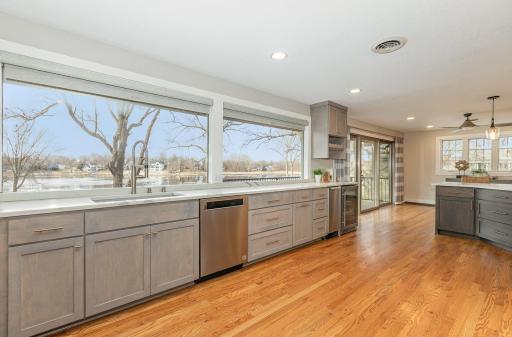 Massive gourmet kitchen features large picture windows and 3-panel sliding glass doors that overlook lake view.