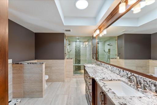During the daytime, it's hard to tell when lights are off in the primary bathroom because of the large amount of natural light from this skylight in the ceiling.