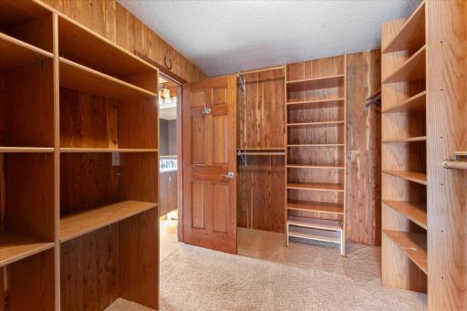The walk-in closet in the primary bedroom has built-in shelving and clothing rods.