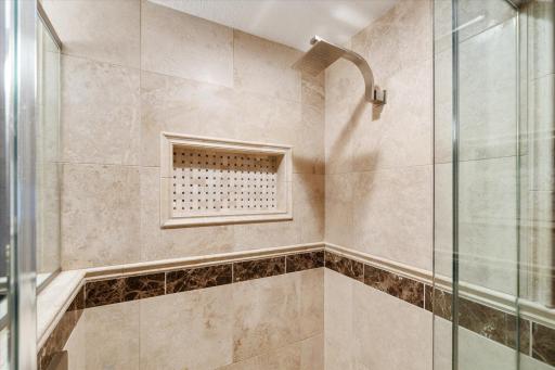 The main floor guest bathroom has a walk-in shower with nice tile detail and a glass door.