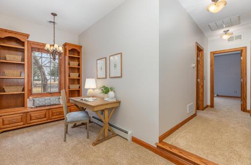 Upper-level loft/den area with built-in cabinets and shelving.