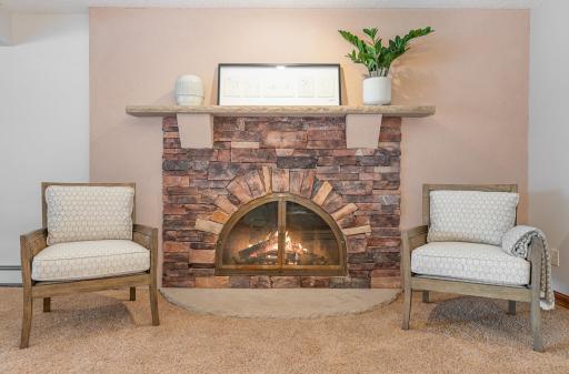 Lower level flex space has a beautiful stone fireplace and mantel to add warmth to the room.