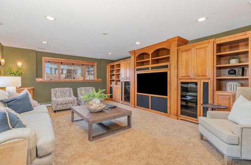 Built-in, high-end cabinets span an entire wall in the lower-level family room. Plenty of storage exists within the cabinets for media and a large tv so that this can become your family's theater room!
