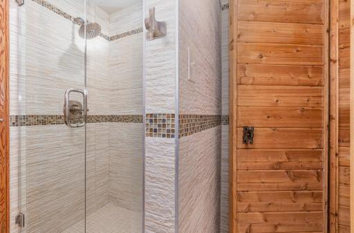 The entrance to the sauna is located on the shower side of the lower-level guest bathroom.