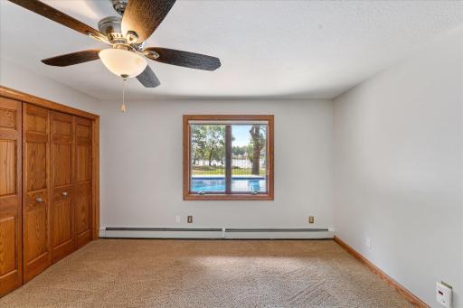The second bedroom in the lower level with a window overlooking the pool and lake.