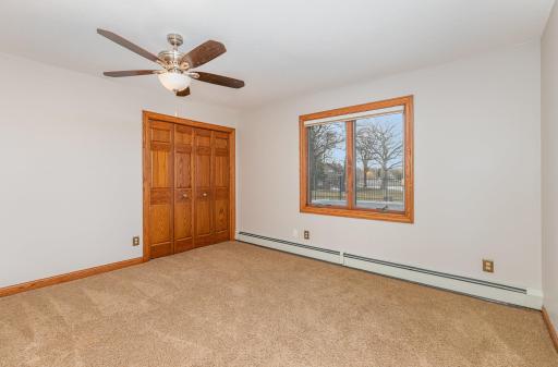 The second bedroom in the lower level features a ceiling fan and closet with 3-panel bi-fold doors.