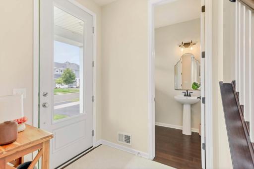 Spacious and bright entry welcomes guests with a convenient closet and half bath