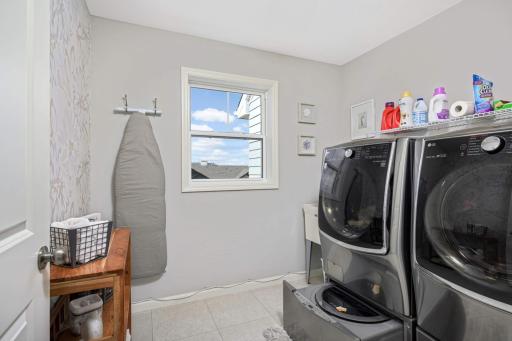 Small load washer under the main washer, storage drawer under the dryer and an accent wall of wallpaper makes this both functional and fashionable.