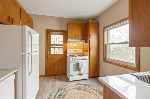 Kitchen with ample storage, new flooring, new dishwasher, new countertop and sink. Large south-facing window and access to backyard for grilling!