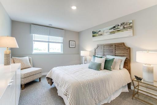 Tucked down in the lower level, and away from the hustle and bustle of the main level living spaces, this bedroom resides adjacent to a full bath and serves as the perfect guest room or your home office! Photo is of model home.