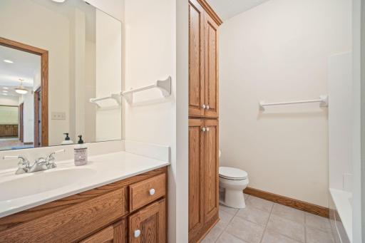 Main level full bathroom with tile flooring, linen closet, & more.