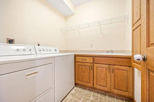 Main level laundry room with sink and more cabinetry.