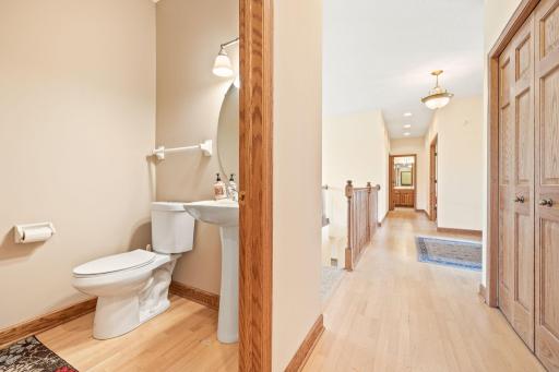 The powder room is nicely tucked in the hallway with a pedestal sink.