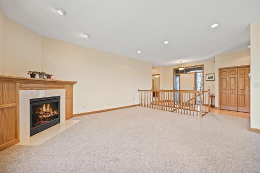 The spacious living room has a gas fireplace, recessed lights, & a very neutral palette for you.
