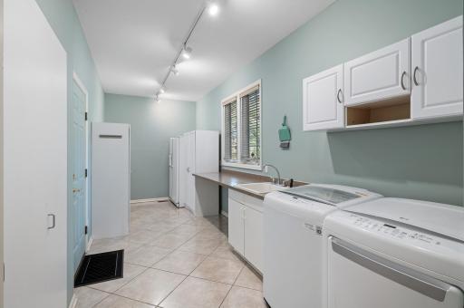 This is the room where stuff gets done! There are two separate entrances to the garage on the left. Laundry sink and folding table and lots of storage for kitchen appliances or games or sports equipment. The second fridge stays with the home.