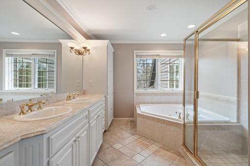 The luxurious bathroom with double sinks, soaking tub, walk-in shower, and heated towel rack completes the suite.