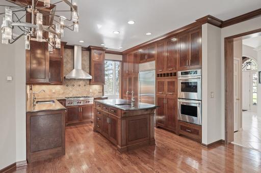 The chef's dream kitchen has custom burl wood cabinetry, top-end stainless appliances, and granite countertops.