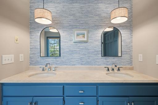 The arched mirrors at the double sinks give nod to one of the many design elements of the home.
