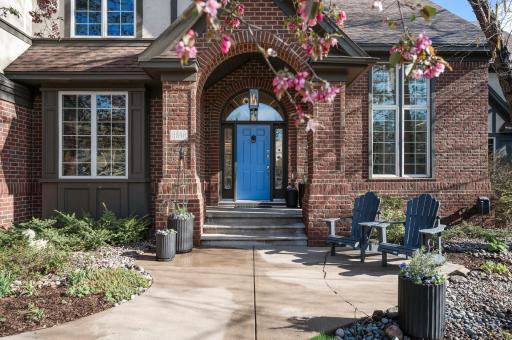 Beautiful blue accent door color pulls in the blooming flowers near the entry.